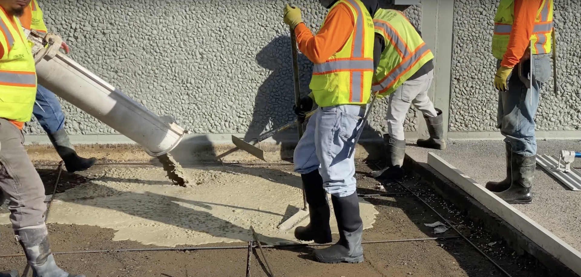 Construction crew working on large-scale concrete project with professional equipment